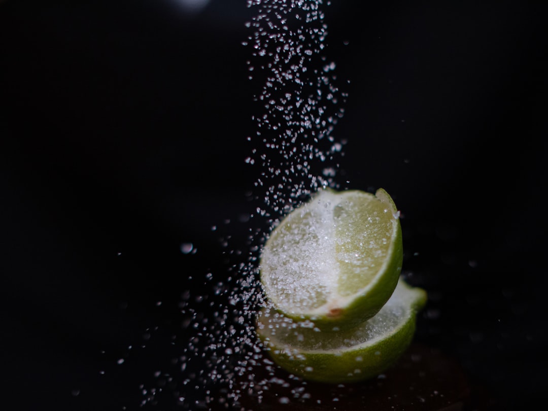 a-slice-of-lime-being-sprinkled-with-sugar-flnppf0uj1s